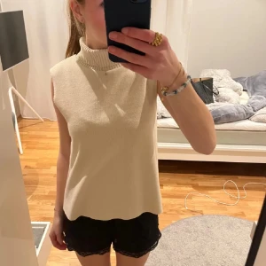 Beige ärmlös polotopp - Säljer en stilren beige ärmlös polotopp i mjukt material. Perfekt för både vardag och festliga tillfällen. Toppen har en hög krage som ger en elegant touch. Passar bra till både jeans och kjol! säljer då jag inte tycker om hur polo tröjor sitter på mig därav då jag inte använt den så den är i nyskick ungefär❤️ köpt på zara för 399 kr ny, 