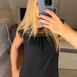 Svart spetsdetaljerad topp från Rosemunde - Säljer en svart topp från Rosemunde med snygga spetsdetaljer vid axlarna och halsen. Perfekt för både vardag och fest! Har används väldigt fåtal gånger så toppen är i mycket bra skick💗💗🥰 
