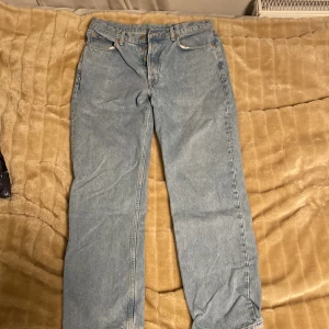 Ljusblå jeans från Dr. Denim - Säljer två par likadana ljusblå jeans från Dr. Denim i modellen Dash och storlek 31/30. De har en klassisk femficksdesign och knappar i gylfen. Perfekta för en avslappnad stil och passar till alla tillfällen. De är i bra skick och redo för en ny ägare!