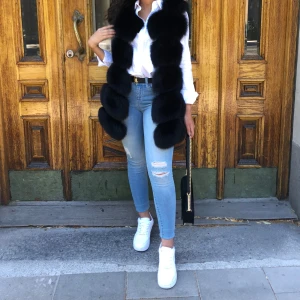 Svart pälsväst - Säljer en superfin svart pälsväst som är perfekt för höst och vinter. Västen har en lyxig och fluffig look, vilket gör den både varm och stilren. Den är i mycket bra skick och passar perfekt för både vardag och fest. Ett måste i garderoben för den som vill hålla sig varm med stil! (Äkta rävpäls)