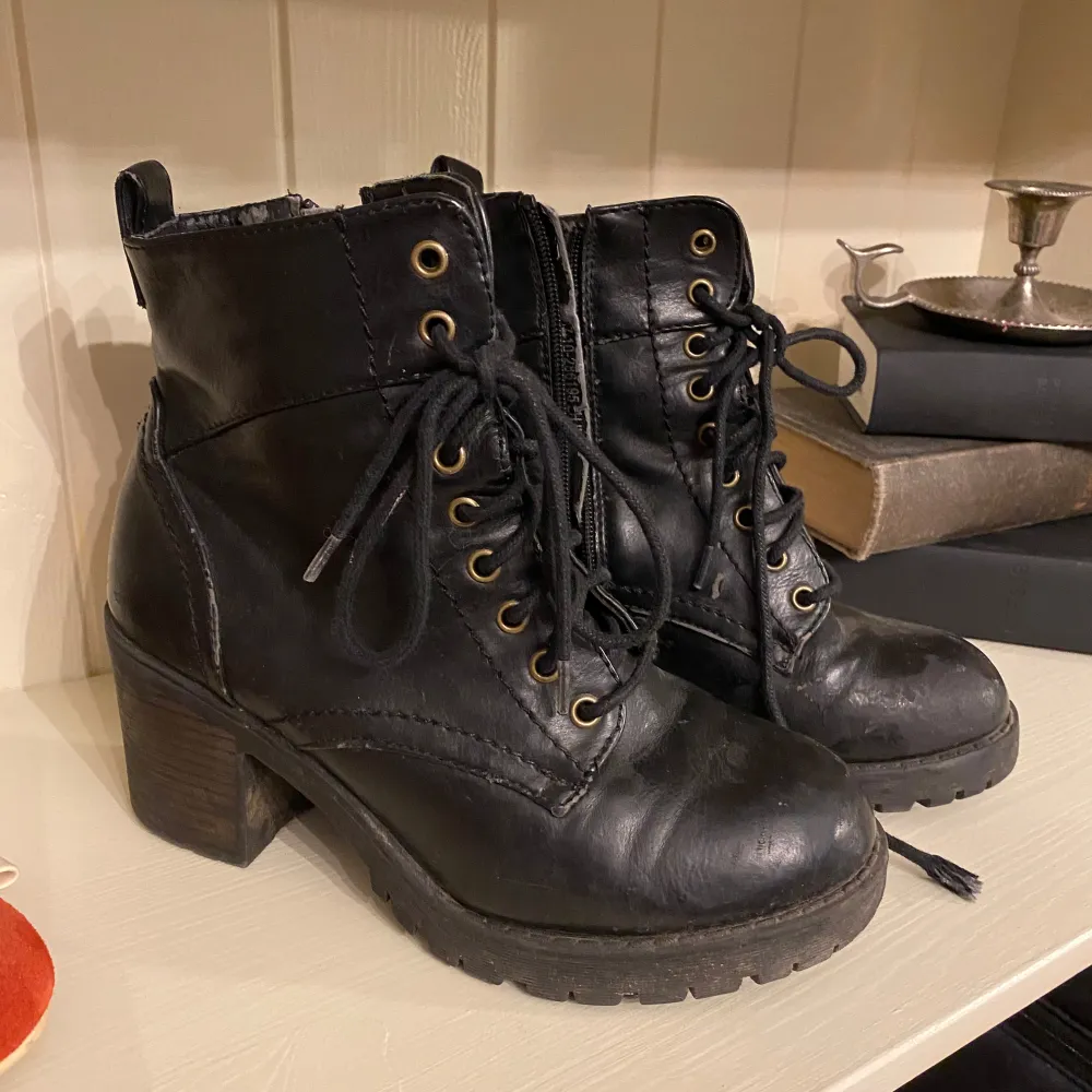 Säljer ett par svarta boots i skinn med klack och snörning. De har en robust design med dragkedja på sidan för enkel på- och avtagning. Perfekta för höst och vinter, och ger en cool look till vilken outfit som helst. Använda men i bra skick.. Skor.