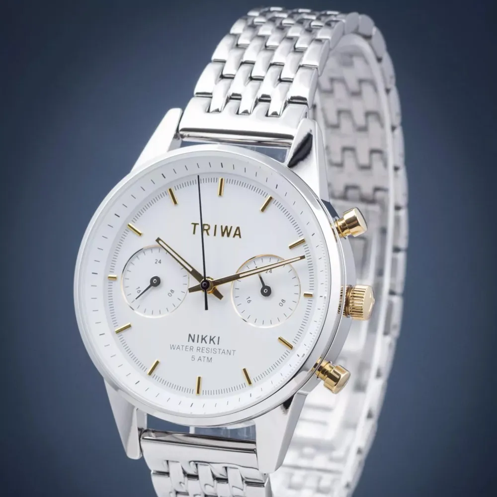 Snygg och stilren klocka från Triwa med silverfärgad länkarmband och vit urtavla. Klockan har två mindre urtavlor och guldfärgade detaljer. Perfekt för den som vill ha en elegant accessoar. Triwa Gleam Nikki NKST101. Nypris 2499kr. Asusteet.