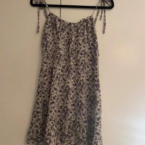 Blommig sommarklänning med knytband - Jätte söt klänning från shein helt oanvänd men säljer då den är lite för liten! Då den köptes ganska billigt så säljer jag den billigt på grund av det! 