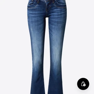 Blå bootcut jeans från LTB - Snygga blå bootcut jeans från LTB med klassisk femficksdesign och subtila slitningar. De har en knappgylf och är perfekta för en avslappnad stil. Passar bra till både sneakers och klackar.