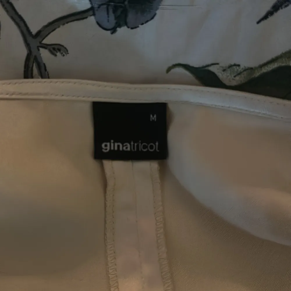 Omlottopp i satin från Gina Tricot. Toppen har långa ärmar och en v-ringning.. Toppar.