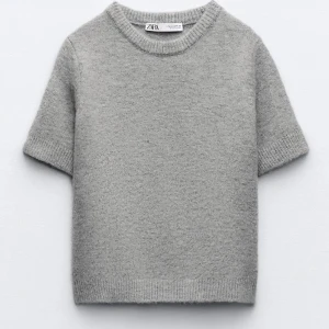 Grå stickad T-shirt från Zara - Säljer grå stickad T-shirt från Zara i storlek S. T-shirten är i bra skick och bara använd fåtal gånger! Kontakta mig för fler bilder