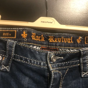 Blå jeans från Rock Revival - Snygga blå jeans från Rock Revival med slitna detaljer.