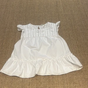 Vit blus från H&M - Säljer en söt vit blus från H&M i storlek M. Den har fina spetsdetaljer på framsidan och volanger vid ärmslut och nederkant. Perfekt för sommardagar eller en avslappnad vårlook. Blusen är i mycket bra skick och redo för en ny ägare!