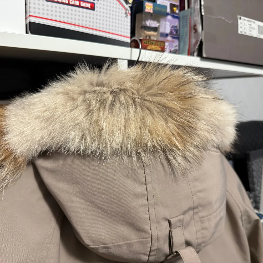 Säljer en snygg beige vinterjacka från Canada Goose i storlek S. Jackan har en avtagbar huva med pälsdetalj och flera praktiska fickor. Perfekt för kalla vinterdagar! 🧥❄️. Jackor.