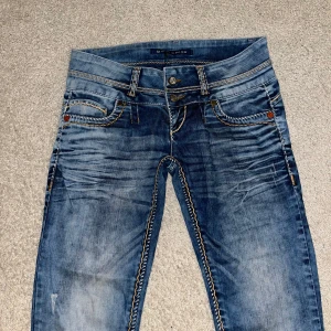 Blå jeans med kontrastsömmar - Snygga blå jeans med coola kontrastsömmar och slitna detaljer.