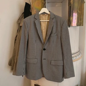 Svart-vit-rutig kavaj från Imperial - Svart-vit-rutig kavaj från Imperial Black Label i storlek M. Kavajen har klassisk passform med två knappar framtill.