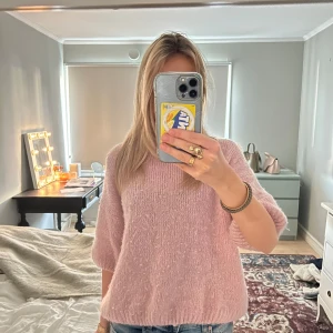 Rosa stickad tröja från Chelsea - Mysig rosa stickad tröja från Chelsea med trekvartsärm. Perfekt för kyligare dagar och ger en avslappnad look. Tröjan har en mjuk och fluffig textur som känns skön mot huden. Lite nopprig, men det går att fixa med en noppringsmaskin💕