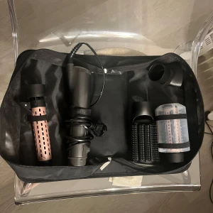 Hårstylingverktyg från Remington - Säljer ett hårstylingverktyg från Remington med flera tillbehör. Setet innehåller en hårtork, rundborste och andra stylinghuvuden, allt i en förvaringsväska.   Säljer den då den inte kommer till användning för att jag fick ett annat styling verktyg tätt inpå!  Använd ett fåtal gånger.  Kontakta mig vid eventuella frågor eller för fler bilder.