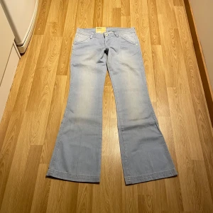 Lågmidjade bootcut jeans från Wrangler  - (16) Ljusblåa lågmidjade bootcut jeans, helt nya med lappar kvar. Midjemått rakt över: 38cm, innerbenslängd: 83 cm. Stretchiga!💕