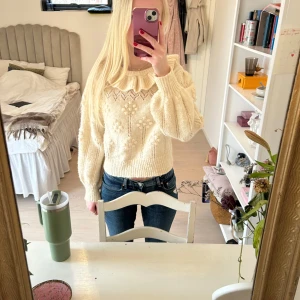 Beige stickad tröja med volangdetalj - Säljer en söt beige stickad tröja med volangdetalj vid halsen. Tröjan har ett fint mönster och långa ärmar. Storlek 164 från Zara men passar som XS/S.