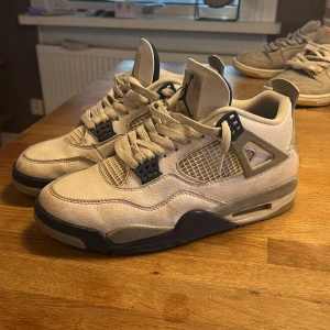 Nike Air Jordan 4 midnight navy  - Säljer ett par klassiska Nike Air Jordan sneakers i vit med blå detaljer. Skorna har snörning och en robust sula med röda och blå inslag. Perfekta för dig som älskar en sportig och stilren look. Dessa är äkta org låda följs med storlek44!
