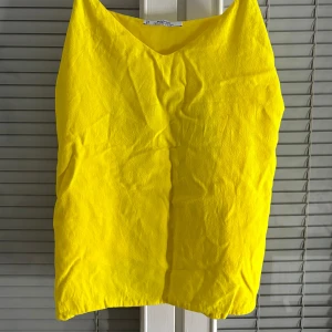 Gul linnetopp från Mango - Säljer en solgul linnetopp från Mango. Toppen har en enkel och stilren design med smala axelband och en lös passform. Perfekt för varma sommardagar. 🌞