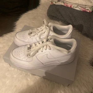 Vita Nike Air Force sneakers - Säljer ett par klassiska vita Nike Air Force sneakers som är använda fåtal gånger och fortfarande väldigt fina. De är tyvärr förstora för mig så måste sälja dem:(. Nypris 1499 k h mitt pris är 600🌸600 kr är fast pris😊