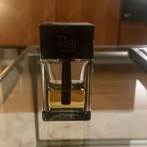 Dior Homme Intense Eau de Parfum - Säljer en flaska Dior Homme Intense Eau de Parfum, 50 ml. Flaskan har en elegant design med en svart topp och genomskinligt glas som visar den gyllene vätskan inuti. Perfekt för den som söker en sofistikerad och intensiv doftupplevelse.Ca 40% kvar 