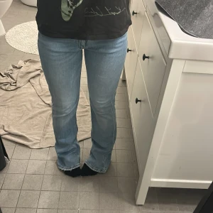 Ljusblå jeans från Gina Tricot - Snygga ljusblå jeans från Gina Tricot med en klassisk design. De har en bootcut-stil som ger en trendig look. Perfekta för en avslappnad stil med en t-shirt eller en mer uppklädd outfit. Midjemåttet eakt över är 36cm och innerbenslängden är 38cm.