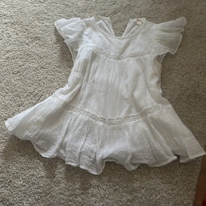 Vit blus från Gina Tricot - Säljer en söt vit blus från Gina Tricot i storlek 146/152. Blusen har en luftig design med korta ärmar och fina spetsdetaljer. Perfekt för varma dagar med sin lätta och bekväma passform. 🌸