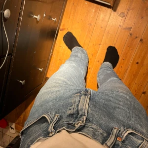Blå jeans från H&M - Säljer ett par blå jeans från H&M i relaxed fit. De har en klassisk femficksdesign med dragkedja och knapp. Perfekta för en avslappnad stil. Passar 33/32