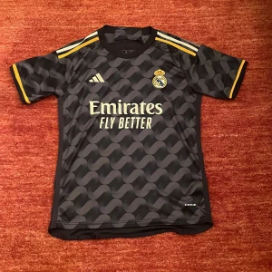 Real Madrid tröja - Jättesnygg Real Madrid fotbollströja med VINI JR nummer 7 på ryggen. Har använt den endast 2 gånger och är som ny. Storlek S. Pris går att diskuteras!