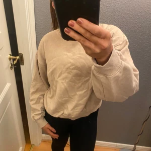 Beige tröja från Bik Bok - Säljer en supermjuk och bekväm beige tröja från Bik Bok i storlek XS. Perfekt för mysiga dagar hemma eller en avslappnad dag ute. Tröjan har långa ärmar och en klassisk rund halsringning. Passar perfekt till jeans eller leggings!