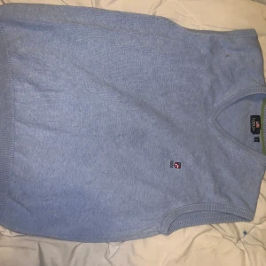 Ljusblå stickad väst från U.S. Polo Assn. - Säljer en ljusblå stickad väst från U.S. Polo Assn. i storlek S. Västen har en klassisk v-ringad design och är perfekt för lager-på-lager under höst och vår. Den är i mycket bra skick och har en liten logga på bröstet. Perfekt för en stilren och avslappnad look!