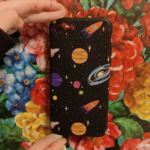 Iphon sju - Säljer ett coolt svart mobilskal från Just in Case med rymdmotiv. Skalet har färgglada planeter och raketer som ger en unik look. Det är i bra skick och skyddar din mobil samtidigt som det ser snyggt ut. Perfekt för dig som älskar rymden! 🚀✨