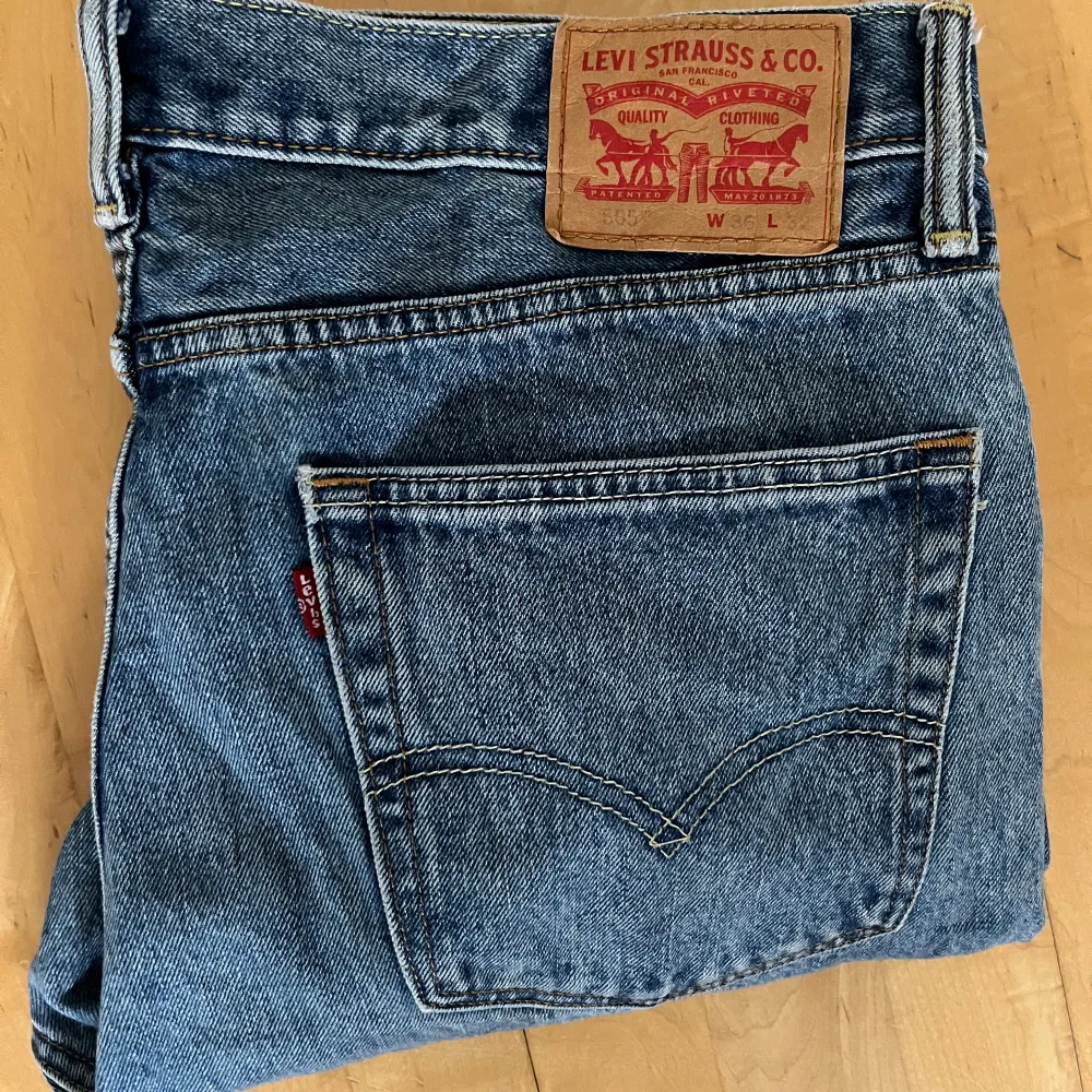 Säljer ett par klassiska Levi's jeans i blå denim. De har en straight passform och är högmidjade, perfekt för en avslappnad stil. Jeansen är i mycket bra skick och har den ikoniska Levi's-lappen på baksidan. Perfekta för både vardag och fest!. Jeans & Byxor.