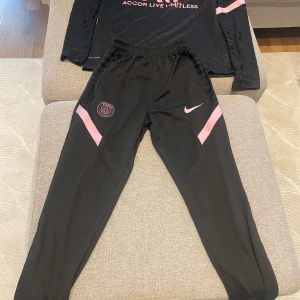 Svarta Nike Dri-FIT träningsbyxor med överdel  - Säljer ett par svarta Nike Dri-FIT träningsbyxor med överdel i storlek S. Den är i väldig fin skick och knappt använd. 