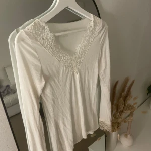 Vit långärmad topp från Intimissimi - Säljer en superfin vit långärmad topp från Intimissimi i ultralätt material med kashmir. Den har vacker spetsdetalj vid halsringningen och ärmsluten. Perfekt för både vardag och fest! 😍