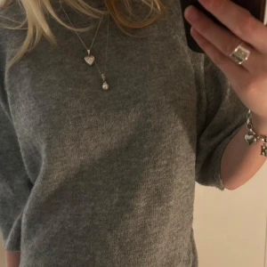 Grå stickad trekvartsärmad tröja - Mysig grå stickad tröja med trekvartsärm. Perfekt för kyliga dagar och passar till både vardag och lite finare tillfällen. Tröjan har en enkel och stilren design som gör den lätt att matcha med olika accessoarer 💗