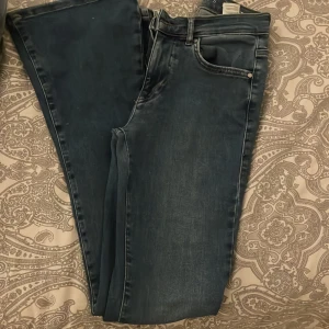 Blå low flare jeans - Säljer ett par snygga blå low flare jeans i storlek S. De har en klassisk femficksdesign och passar mig som är 158 perfekt. Jeansen har en låg midja och en bekväm passform😊
