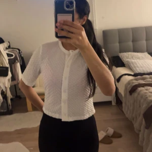Vit kortärmad blus - Säljer en söt vit blus med korta ärmar och knappar framtill. Den har en fin textur och är perfekt för både vardag och fest. Passar bra till både jeans och kjol!🥰🥰🥰