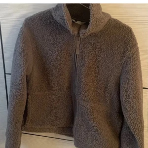 Brun teddyjacka med dragkedja - Mysig brun teddyjacka från HM i mycket bra skick. Perfekt för höst och vinter med sin varma och gosiga känsla. Jackan har en dragkedja framtill och långa ärmar. Den är i en normal passform och passar perfekt för kyliga dagar. I storlek S. Pris går att diskutera 💕