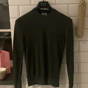 Säljer en stilren mörkgrön tröja från H&M i slim fit. Perfekt för både vardag och fest. Tröjan är långärmad och har en enkel design som gör den lätt att matcha med andra plagg. Passar bra till höst och vinter. 🧥🍂