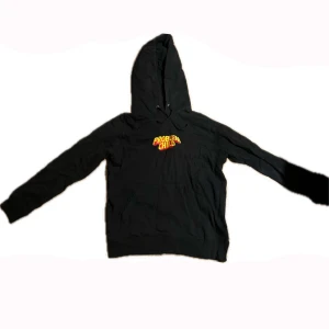 Svart hoodie från Golf - Säljer en svart hoodie från Golf med texten 'Problem Child' i gult och rött på bröstet. Perfekt för en avslappnad stil och passar bra till både jeans och joggers. Den har en klassisk passform med huva och dragsko. Perfekt för höst och vinter!