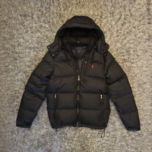 Svart jacka från Polo Ralph Lauren - Säljer nu min sjukt snygga vinterjacka från Polo Ralph Lauren i storlek S. Jackan är i nyskick och har använts mycket varsamt vid få tillfällen. Köpte Jackan i slutet av förra vintern på boozt och har inga tecken på användning eller skador. Nypris ligger på runt 5000 kr och mitt pris är 3199 kr. Hör av er vid frågor och funderingar!🙌🏼