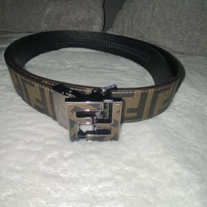 Fendi bälte  - Säljer ett snyggt Fendi bälte. Bältet har ett stilrent metallspänne som ger en lyxig känsla. Perfekt för att piffa upp vilken outfit som helst! Passar både till vardags och fest. Obs:skriv innan köp