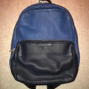 Äkta läder ryggsäck från Marc by Marc Jacobs.   Säljer en snygg ryggsäck i blått och navy skinn från Marc by Marc Jacobs. Den har en praktisk dragkedja och justerbara axelremmar. Perfekt för både vardag och andra tillfällen. Väskan är i bra skick och redo för nya äventyr! Nypris 5000:-