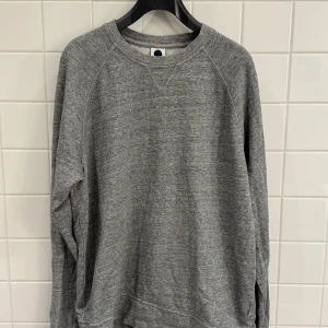 Grå sweatshirt från NN07 - storlek S - Säljer en stilren grå sweatshirt från NN07 i 100% bomull. Perfekt för både vardag och chill. Tröjan har en klassisk rund hals och långa ärmar. Den är i bra skick och passar perfekt till höst och vår. Skön och enkel att matcha med det mesta!