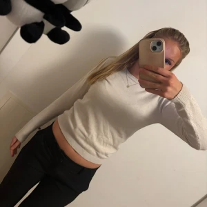 Vit stickad tröja - Säljer en superfin vit stickad tröja i mycket bra skick. Den är långärmad och har en tight passform som framhäver figuren. Perfekt för både höst och vår, och funkar lika bra till vardags som till fest. Tröjan är mjuk och bekväm, och den ribbade kanten ger en snygg detalj. Passar perfekt till jeans eller kjol!