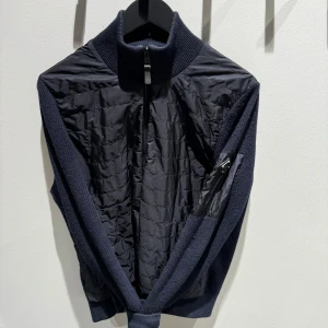 J.Lindeberg Cardigan Marinblås S - J.Lindeberg Cardigan i marinblå, Cond 9/10 nästintill nyskick endast normalt slitage på det stickade, inga hål. Tillverkas ej längre. Storlek S, Vid en snabb samt smidig affär är priset självklart diskuterbart. Via specifikt instabox fraktas även på helgen. Fraktas välinpackad senast dagen efter köp!