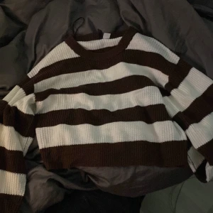 Brun och vit randig tröja från H&M Divided - Säljer en superfin brun och vit randig tröja från H&M Divided. Den är croppad och stickad, perfekt för höst och vår. Tröjan har långa ärmar och en skön passform. Perfekt för en avslappnad stil! 🍂🤎