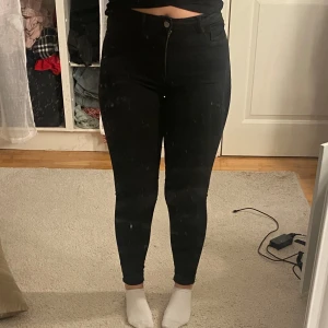 Svarta skinny jeans - Säljer ett par svarta skinny jeans i mycket bra skick. De är högmidjade och har en enkel design med knapp och dragkedja framtill. Perfekta för både vardag och fest! Passar till allt och är superbekväma. Storlek dam M.