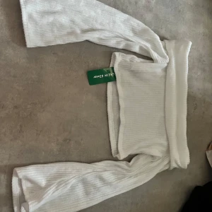 Vit ribbad tröja från Shein - Säljer en superfin vit ribbad tröja från Shein. Den är i storlek L och har långa ärmar samt croppad. Helt ny och oanvänd!