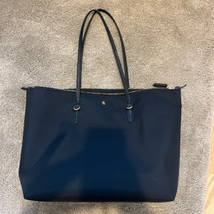 Ralph Lauren väska - Köpt på NK. Väldigt stilren. Perfekt som skolväska. Använd fåtal gånger så den är i väldigt bra skick. Har ett innerfack. Guldiga detaljer.