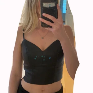 Topp - Topp i läderimitation. Aldrig använd, storlek XS. Justerbara band och dragkedja på sidan. Vid frågor/fler bilder är det bara att skriva. Tar emot prisförslag❤️